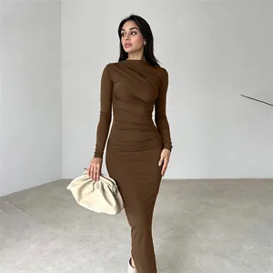 Close-up van elegante koffiebruine nauwsluitende maxi-jurk met lange mouwen en ruches