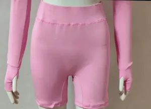 Vue détaillée du short de yoga rose et du haut à manches longues avec passe-pouces