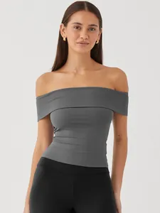 Detailed view showing the elegant grey off-the-shoulder fitted top on a female model