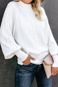 Close-up of white cable-knit sweater with elegant balloon sleeves and mock neck.