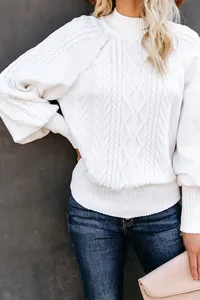 Close-up of white chunky cable knit sweater with elegant lantern sleeves detail