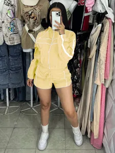 Close-up of a yellow sporty two-piece set featuring a zip-up jacket and shorts for summer