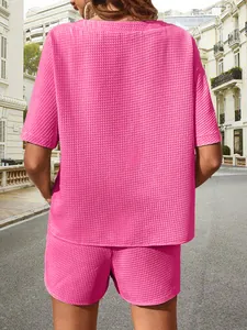 Vue arrière d'un ensemble deux pièces rose vif pour femme en maille gaufrée avec haut et short