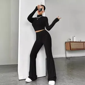 Women's two-piece black knit set featuring long sleeve crop top and wide leg flared pants
