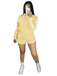 Pale yellow two-piece sports set with white stripes including jacket and shorts detail