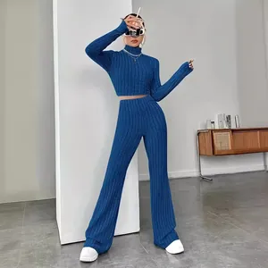 Trendy two-piece blue ribbed knit set featuring a high neck crop top and flared pants