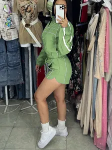 Detailed side view of a green two-piece athletic tracksuit featuring white stripe accents
