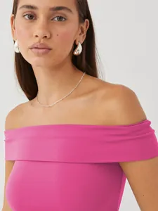 Detailed view of hot pink off-the-shoulder top showing neckline and fabric texture