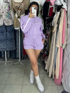 Mirror selfie of a purple two-piece sports jacket and shorts set with white piping