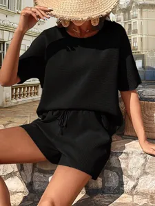 Détail d'un ensemble deux pièces noir pour femme avec haut chauve-souris et short