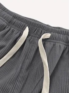 Nahaufnahme der Cordstruktur an grauer elastischer Bundhose mit Kordelzugdetail