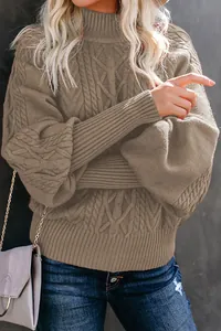 Detailed view of taupe cable-knit sweater with elegant lantern sleeves and high neck.