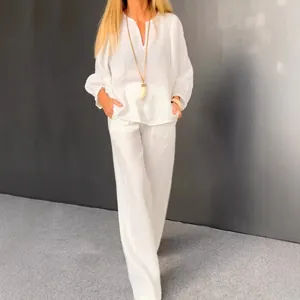Elegant white two-piece cotton linen set featuring long-sleeve V-neck top and wide-leg trousers