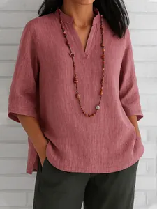 Detail view of V-neck design and linen fabric texture on a casual rose-colored shirt