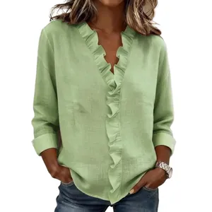 Dettaglio di una camicia da donna in cotone e lino verde con volant e scollo a V