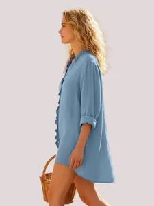 Side view of a blue ruffle long sleeve shirt paired with a wicker basket.