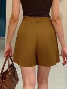 Back view of high-waisted mustard brown A-line shorts for women in a street style