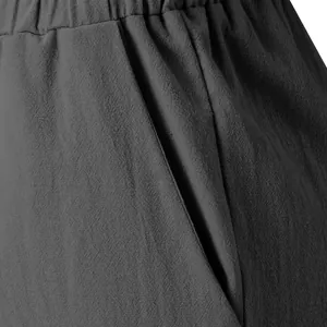 Close-up of dark gray linen fabric texture and side pocket on summer wide-leg pants