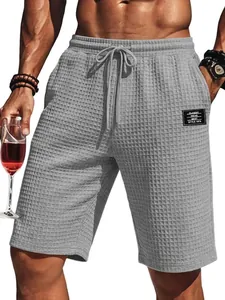 Men's casual grey waffle knit shorts featuring a drawstring waist and stylish patch