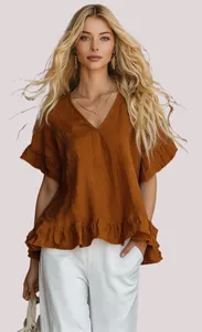 Detail einer eleganten braunen V-Ausschnitt-Bluse mit Rüschenärmeln und ausgestelltem Saum.