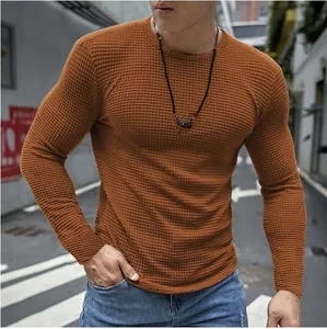 Nahaufnahme eines schmal geschnittenen Herren-Langarmshirts mit Waffelstrickmuster in Orange
