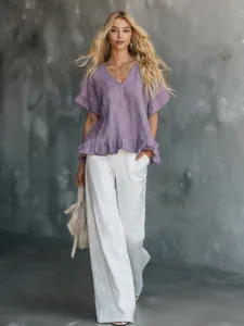 Detailansicht einer eleganten lavendelfarbenen V-Ausschnitt Bluse mit Rüschen und weißer Hose