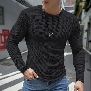 Detail eines schwarzen, eng anliegenden Waffelstrick-Langarmshirts für Herren im Freien