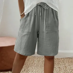 Close-up detail of grey cotton linen shorts with drawstring waist and patch pockets