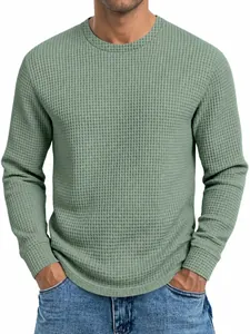 Gros plan sur la texture en maille gaufrée d'un sweat-shirt à manches longues vert