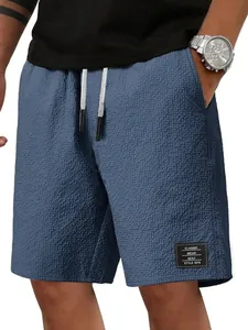 Nahaufnahme blauer Waffelstrick-Herrenshorts mit Textur, Kordelzug und klassischem Aufnäher