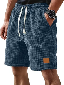 Gros plan d'un short pour hommes en maille gaufrée bleu marine avec écusson en cuir.