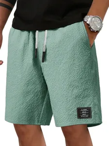 Detailansicht der salbeigrünen Waffelstrick-Freizeitshorts für Herren mit Kordelzugbund.