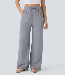 Macro view of grey high-waisted linen wide-leg pants with drawstring on a model.