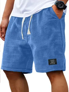 Close-up detail of men's blue waffle knit casual shorts with classic style patch