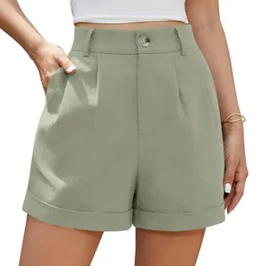 Close-up detail of high-waisted sage green linen shorts with button and front pleats
