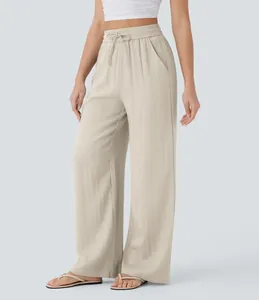 Detailed view of women's beige wide-leg pants with high waist drawstring and side pockets.