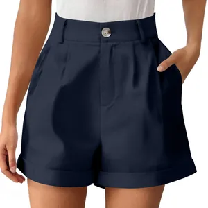 Detail of high-waisted navy blue cotton linen shorts with button and cuffed hem.