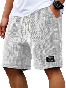 Detailed close-up of waffle texture fabric and decorative patch on men's casual shorts