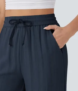 Close-up detail of high-waisted navy linen pants with drawstring and side pocket