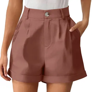 Close-up detail of high-waisted cotton-linen shorts in brown with button closure.