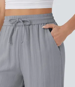 Detail view of gray linen pants featuring an elastic drawstring waist and side pockets.