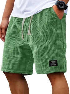Macro view of the high-quality green waffle knit texture on men's casual summer shorts