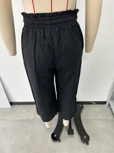 Detailed back view of women's high-waisted black wide-leg trousers on a mannequin.
