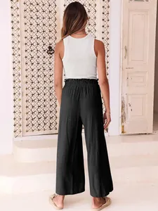 Rear view of comfortable black wide leg trousers with elastic waist styled on a model.