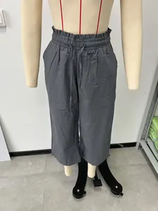 Close-up of grey high-waisted linen trousers with elastic drawstring waist on a mannequin