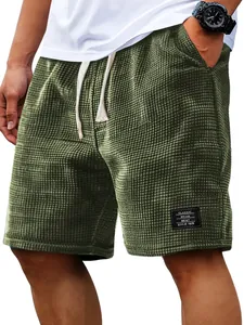 Close-up detail of olive green waffle knit shorts with a classic style patch tag