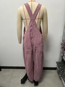 Vista trasera detallada de un mono de pana rosa con tirantes cruzados y dos bolsillos traseros