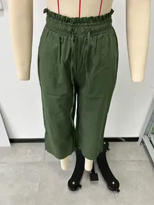 Detail of olive green high-waisted linen trousers with elastic drawstring waist