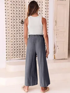 Back view of grey wide-leg cropped trousers featuring an elasticated ruffled waist.