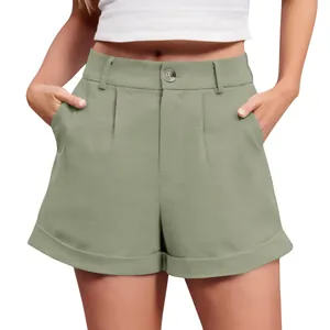 Detail view of sage green high-waisted cotton linen shorts with button and pleated front